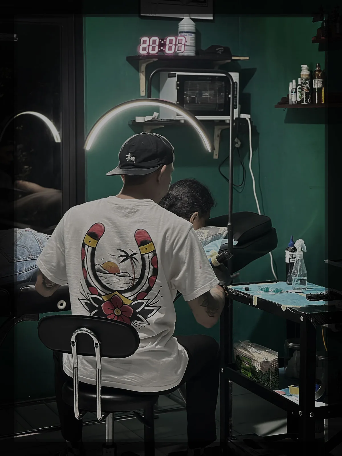 Rian tattoo artist sedang mengerjakan sebuah tattoo pada bagian siku di - Neverfade Studio